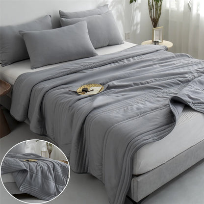 Gray comforter on a bed with a close-up of the texture in a corner.